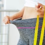 Woman in oversize pants after weight loss, diet concept.