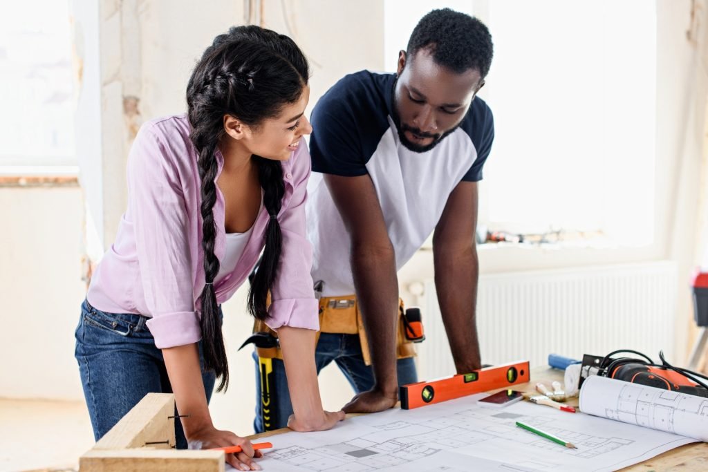young couple with architecture plan making renovation of home together