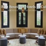 Interior view of VOYA Boutique Hotel in Havana, Cuba—one of the best boutique hotels in Cuba—featuring a stylish lounge with curved sofas, marble tables, and tall windows under soft pendant lighting.