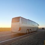 Intercity passenger bus driving on highway in evening