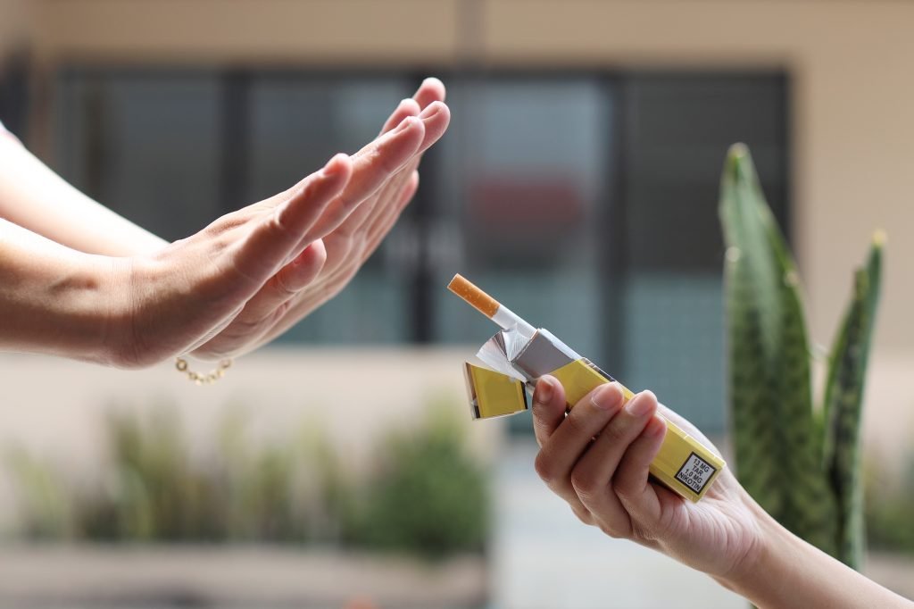 Woman hand refuses a cigarette. Dangerous of smoking