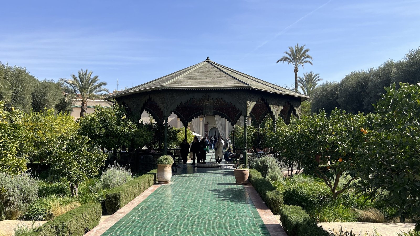 Visitors entering the central pavilion at Le Jardin Secret in Marrakech, a quiet garden retreat often included in a 2 day in Marrakech travel itinerary.