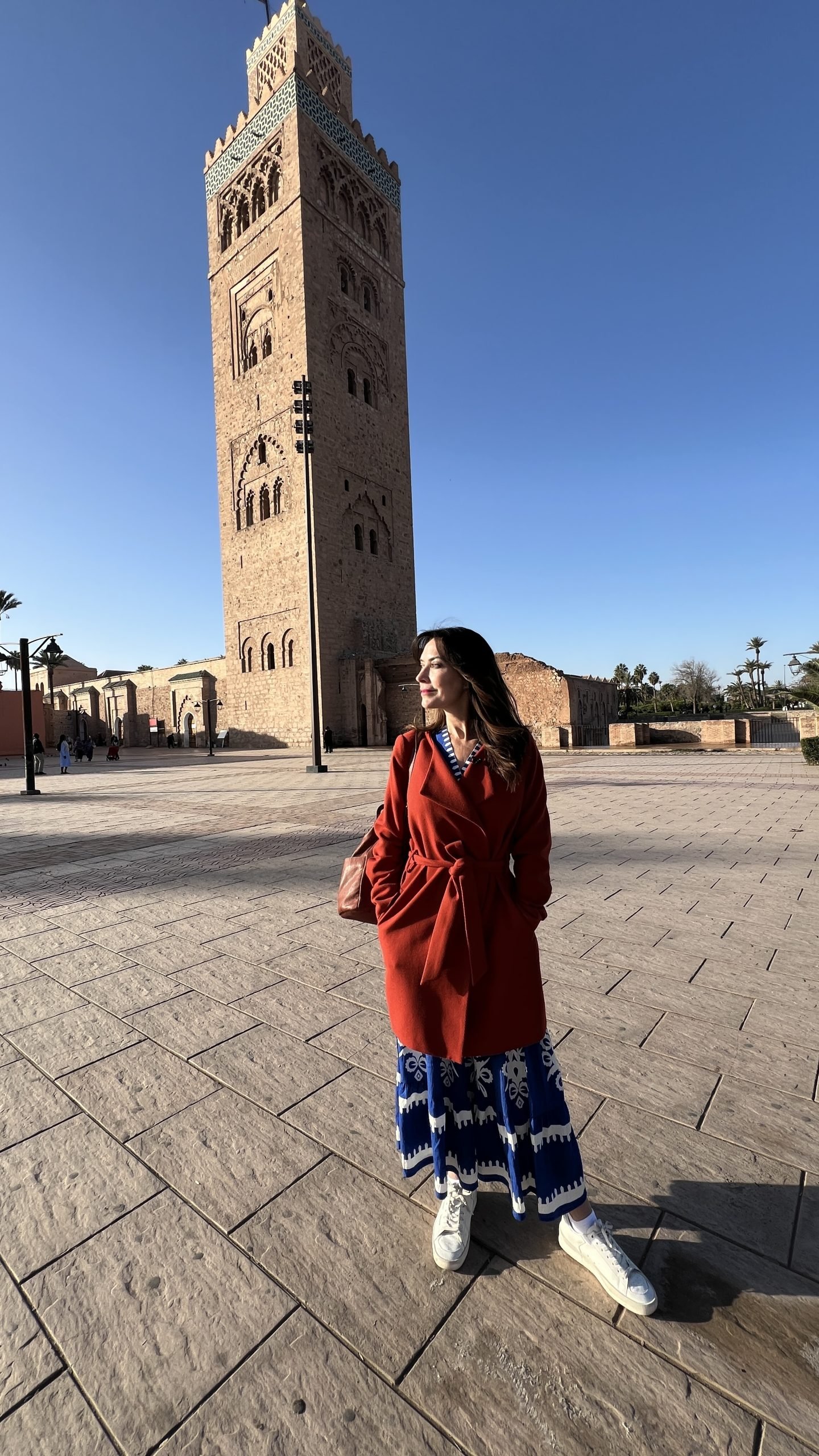 Woman standing in front of Koutoubia Mosque in Marrakech on a sunny day, a popular photo stop during a 2 day in Marrakech itinerary.