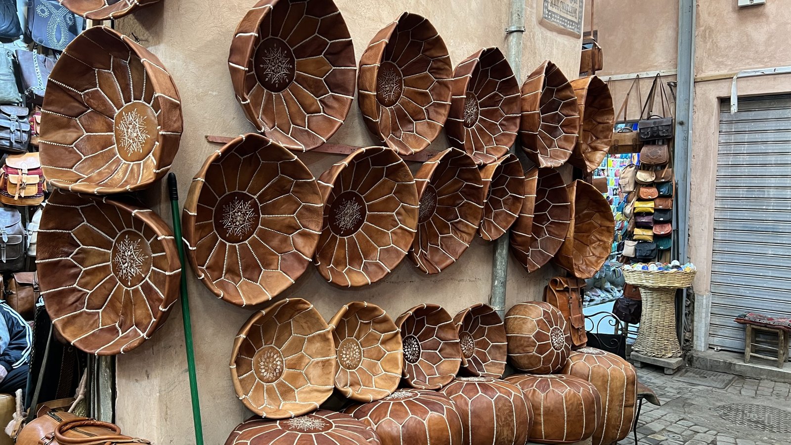 Leather poufs and decor displayed outside a shop in the Marrakech Medina, showcasing local craftsmanship often explored during a 2 day in Marrakech visit.
