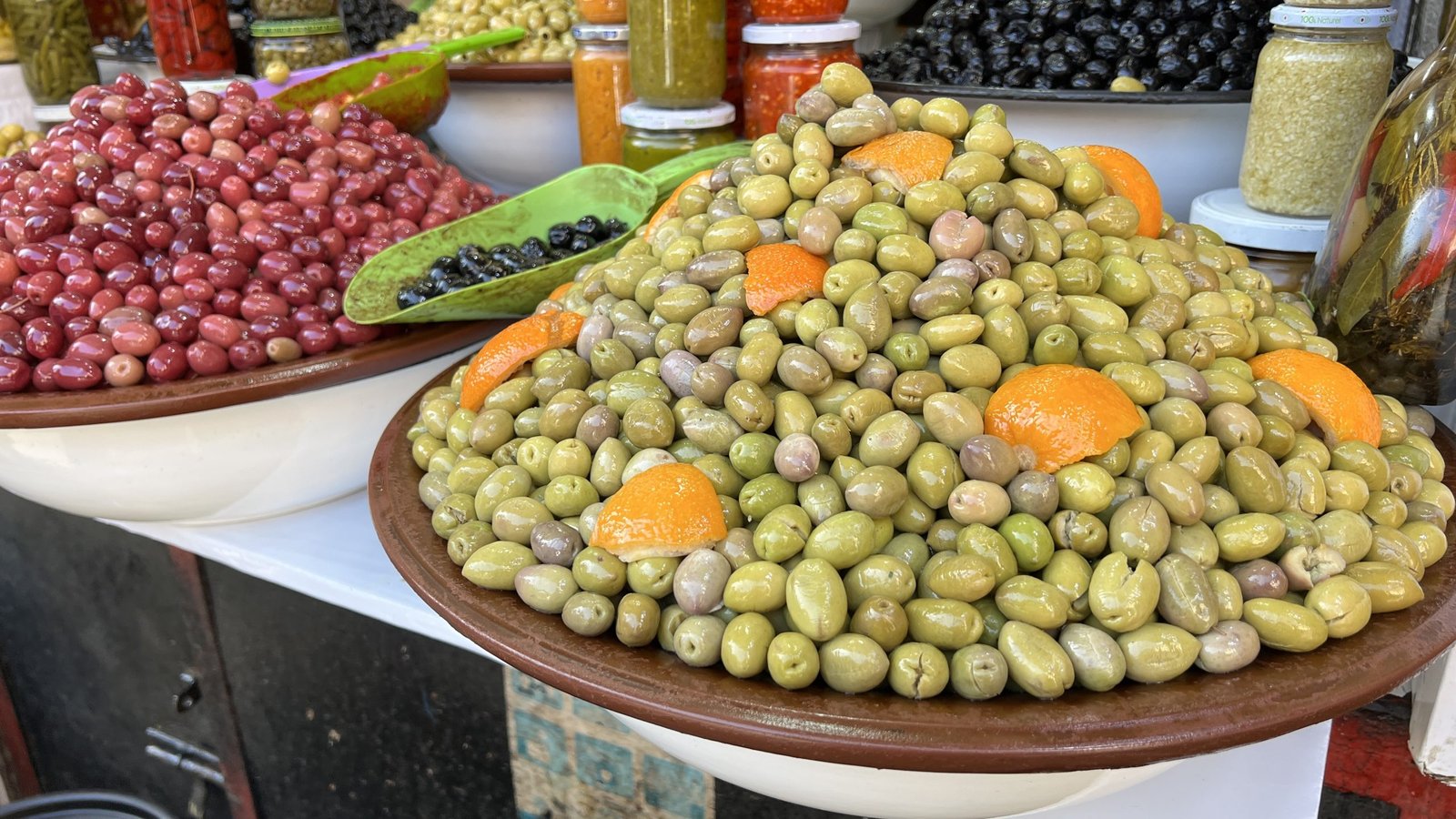 Colorful bowls of olives, preserved lemons, and condiments at a traditional Moroccan restaurant in Marrakech, highlighting the flavors explored in a 2 day itinerary.
