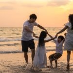 Asian young happy family enjoy vacation on beach in the evening.