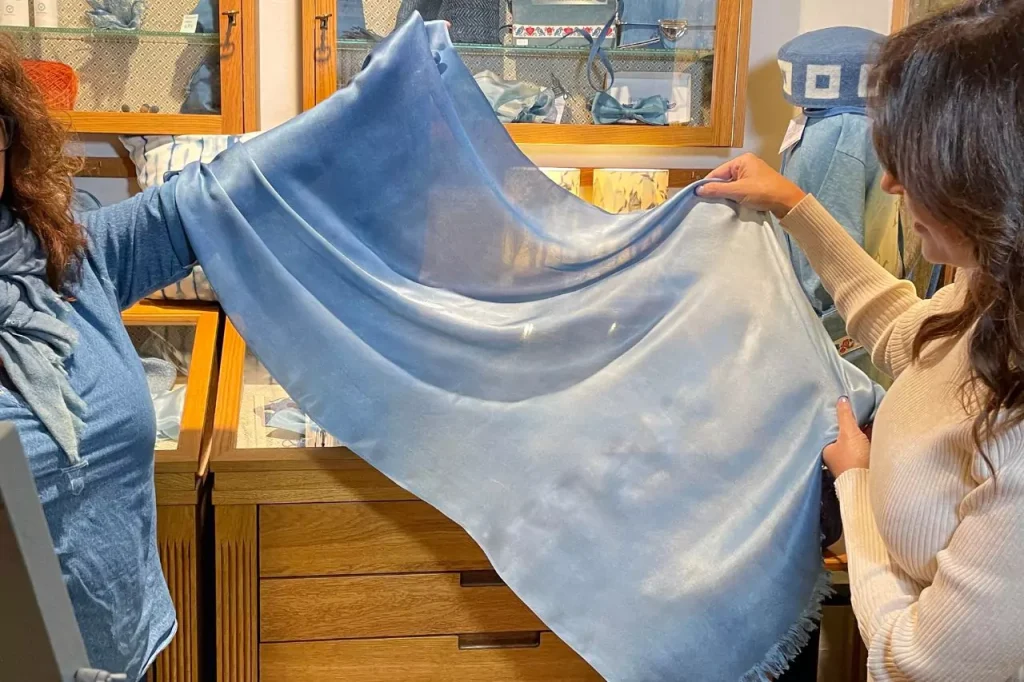 Karen LeBlanc holding a silk scarf dyed in traditional indigo blue at Maboni textile studio in Erfurt