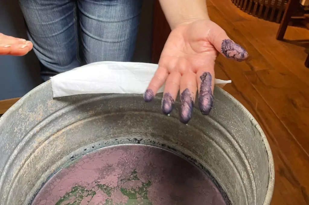 Hands stained with indigo dye during a traditional fabric-dyeing demonstration at Erfurter Blau in Erfurt, Germany