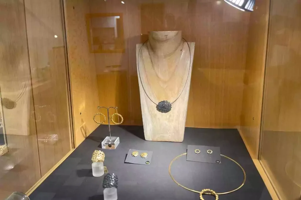 Close-up of handcrafted designer jewelry including earrings, rings, and a pendant necklace on display at Gunda Löhle's studio in Erfurt, Germany.