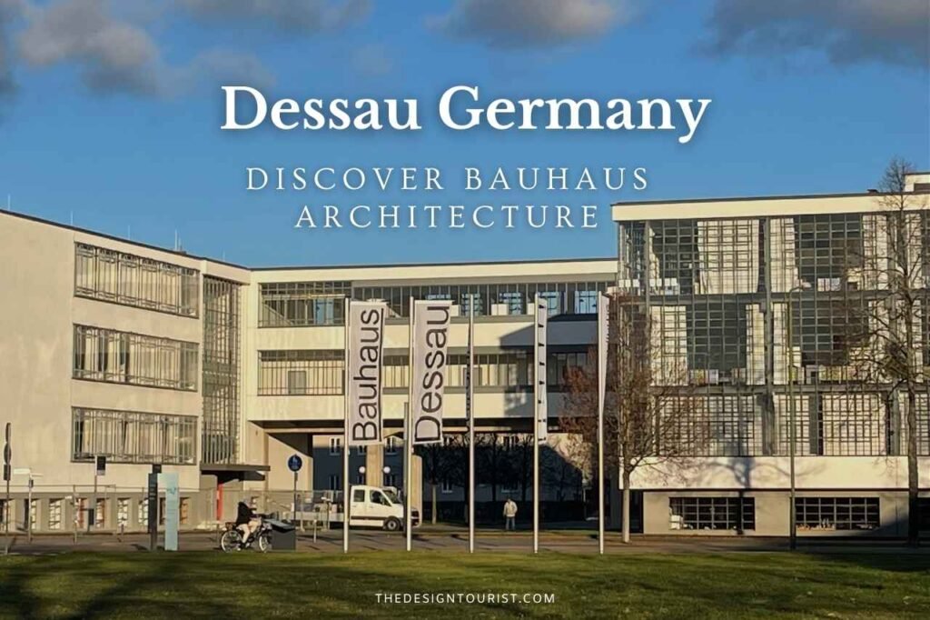 The Bauhaus building in Dessau, Germany, showcasing iconic modernist architecture with glass curtain walls and clean lines; banners reading 'Bauhaus Dessau' stand in front under a blue sky.