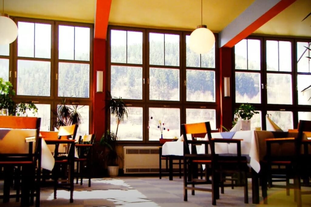 Interior of the House of the People (Haus des Volkes) in Probstzella, Germany, with large windows, modernist furniture, and Bauhaus-style lighting.
