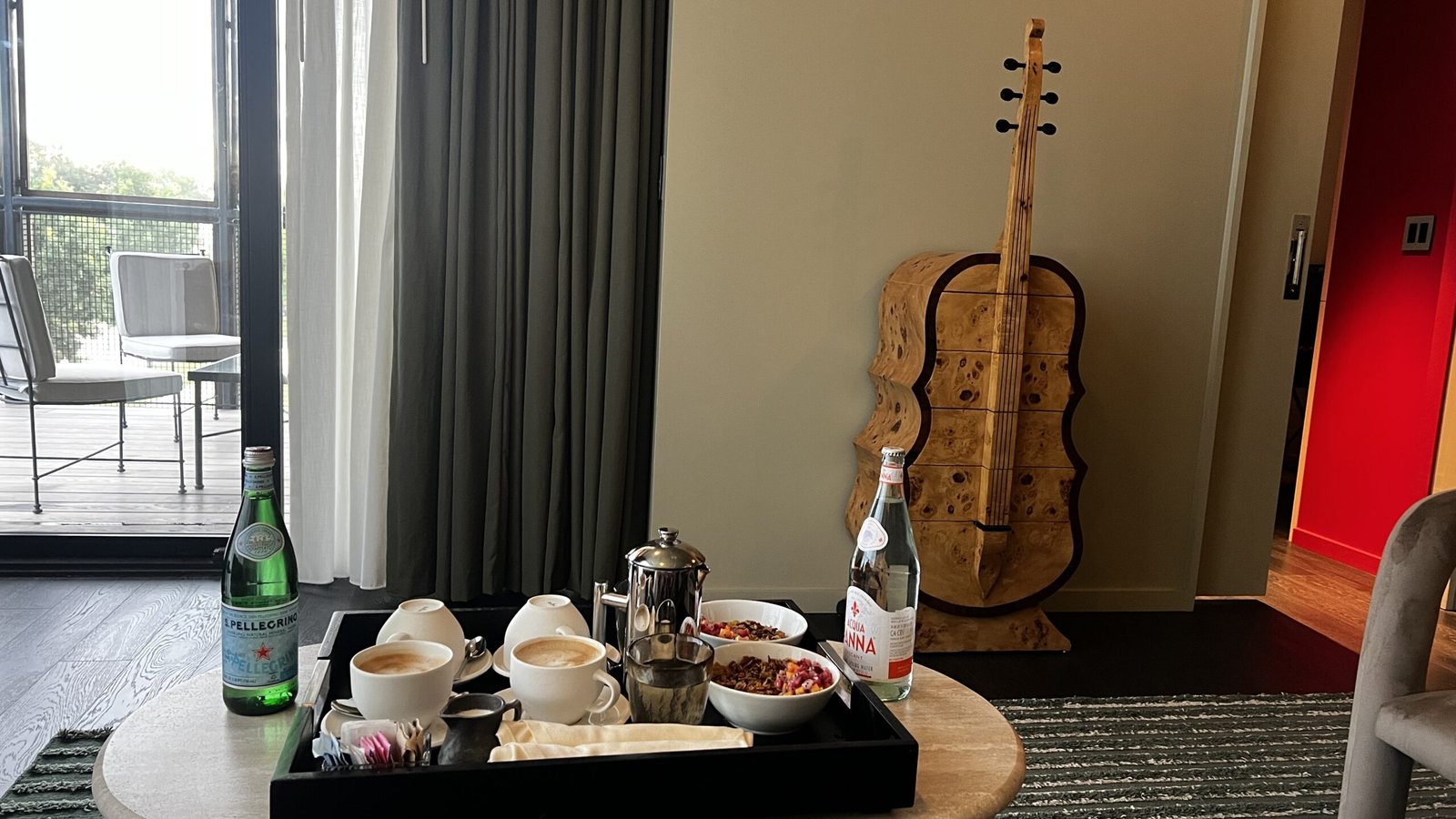 Room service breakfast with coffee, granola, and sparkling water on a table in a suite at Hotel Saint Augustine.