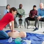 Female instructor showing CPR on training doll