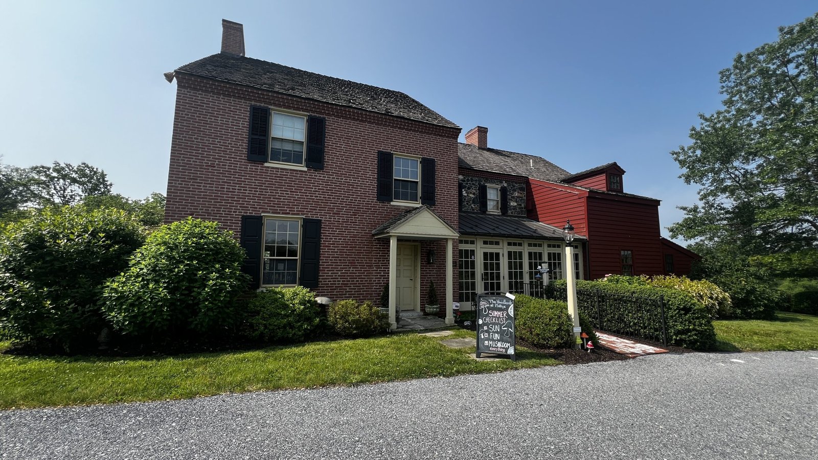 Kennett Square: Exploring the Mushroom Capital of the World Historic red and brick farmhouse in Kennett Square with a small sign out front.