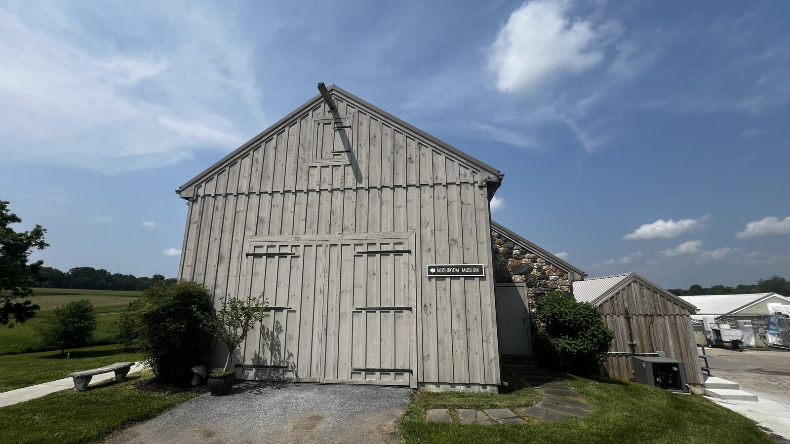 Kennett Square: Exploring the Mushroom Capital of the World Wooden barn-style building with a sign pointing to the Mushroom Museum.