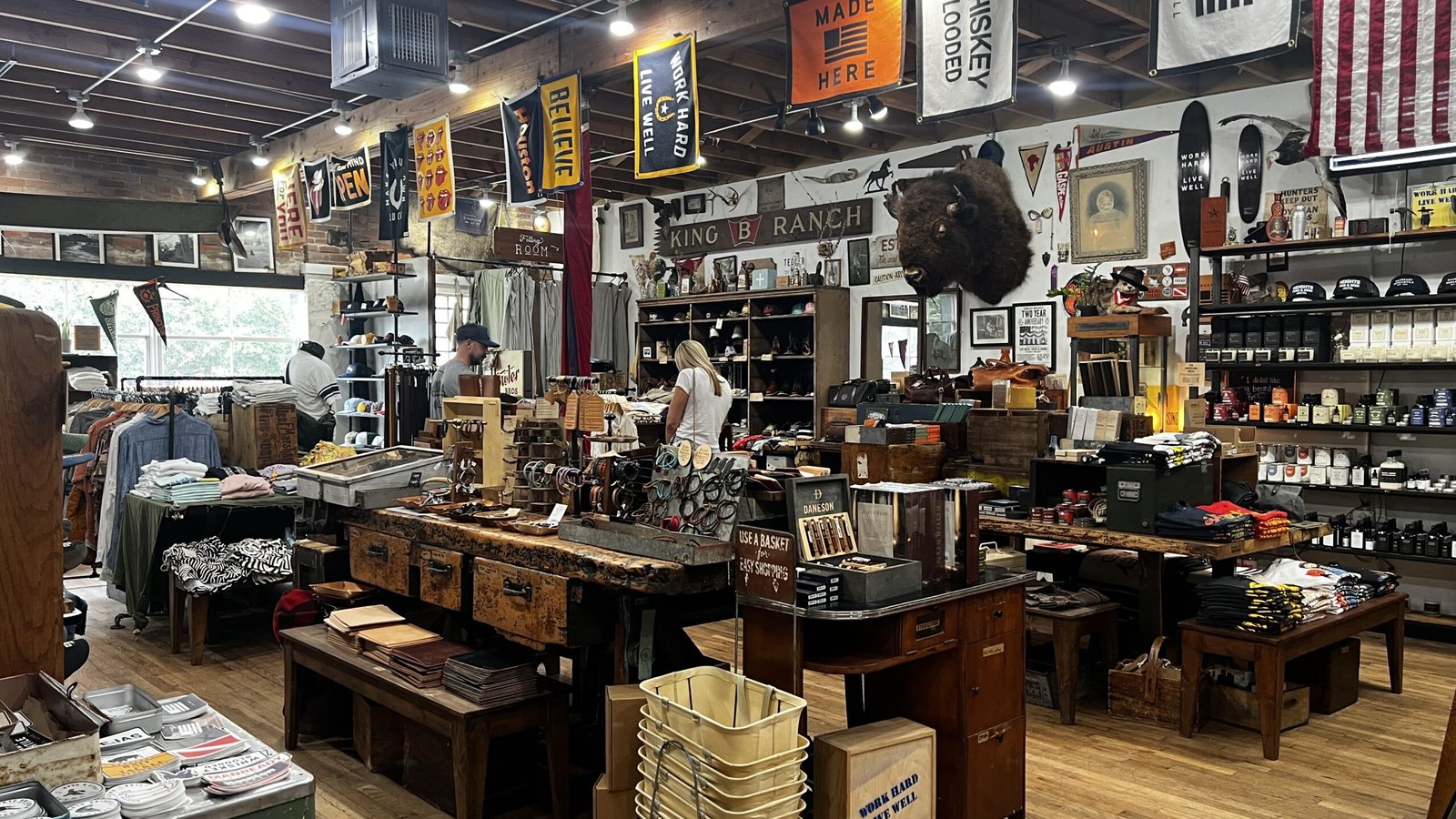 Interior of Manready Mercantile in Houston featuring rustic wooden tables, shelves of handmade goods, vintage décor, and U.S.-made products — a must-visit stop to shop like a local in Houston.