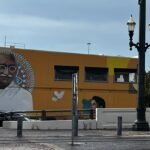 Houston murals showcase global voices, like this Gandhi mural downtown painted in bold colors with doves and cultural motifs symbolizing peace and unity.