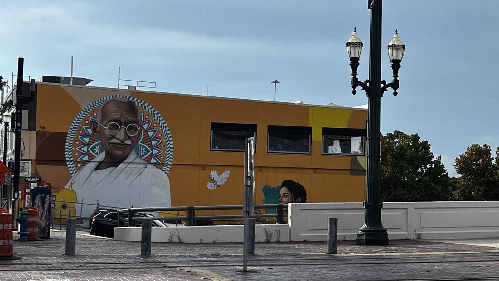 Houston murals showcase global voices, like this Gandhi mural downtown painted in bold colors with doves and cultural motifs symbolizing peace and unity.