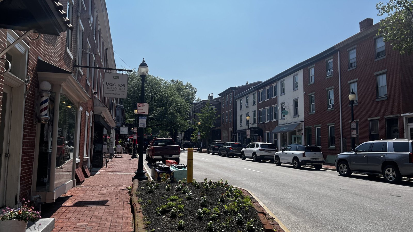 Daytime view of Gay Street in downtown West Chester with shops, parked cars, and pedestrians.