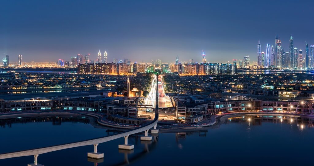 Cityscape of Dubai, United Arab Emirates at dusk, with illuminated skyscrapers in the distance and