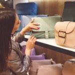 Female customer purchasing new handbag in shop