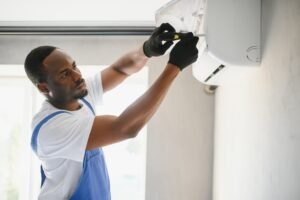 Happy Young African Male Technician Repairing Air Conditioner