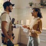 Young master of household maintenance service consulting clients at home