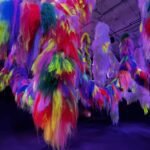 Close-up view of Shoplifter’s Nervescape installation featuring cascading strands of neon faux hair in vivid colors like red, yellow, green, and purple.