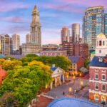 Colorful view of Faneuil Hall and Quincy Market in Back Bay Boston, surrounded by modern skyscrapers.