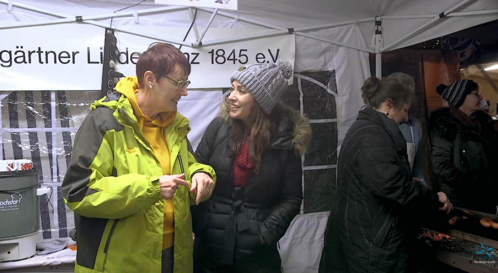 Karen talks with local vendors as sausages grill at the Tübingen Christmas market.