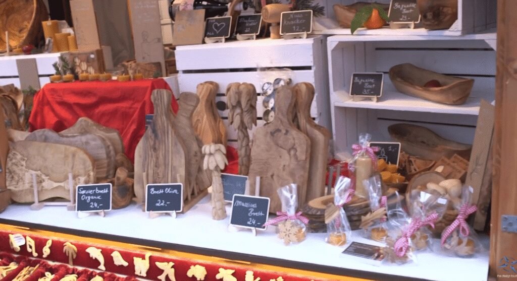 A Freiburg market stall displaying handcrafted wooden boards, bowls, and local artisanal goods.