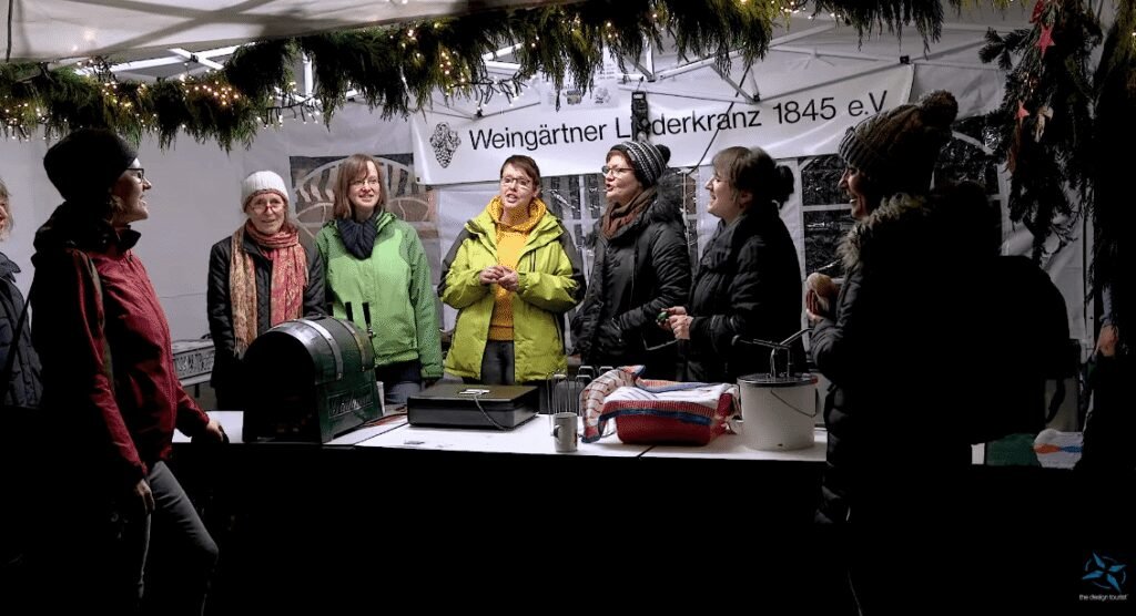 A local choir sings at a festive stall in the Tübingen Christmas market.