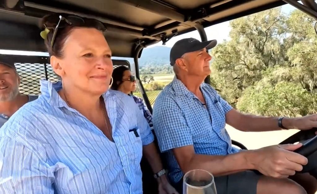 Guy driving an ATV through Ferrington Vineyard with his wife Sarah and Karen LeBlanc during a tour at Fathers + Daughters Cellars.