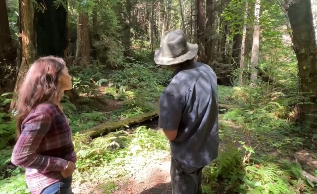Karen and guide Otis walking through the redwood forest at The Inn at Newport Ranch on the Mendocino Coast, exploring the property’s natural landscape and learning about the forest’s ecology.