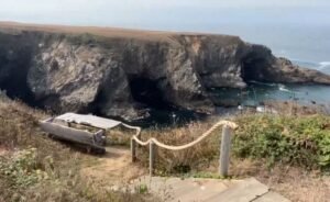 A driftwood bench sits on a cliff edge overlooking the waves along the Mendocino Coast.