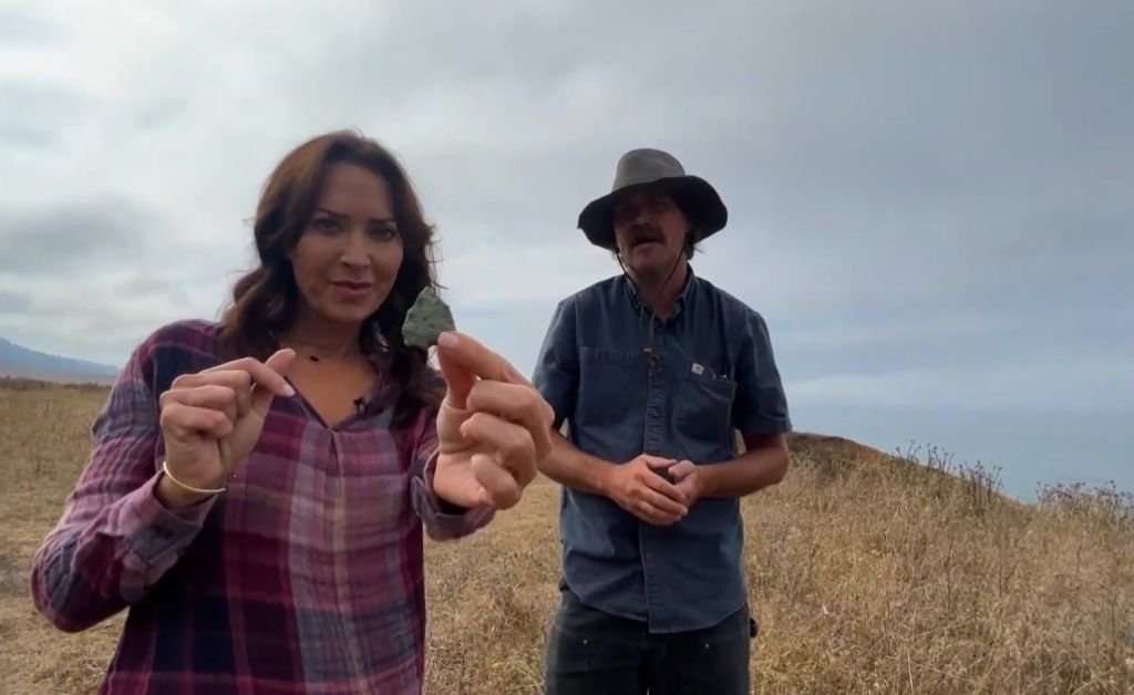 Karen LeBlanc holding a carved projectile point discovered on the bluff, with Otis explaining its Yuki Indian origins.