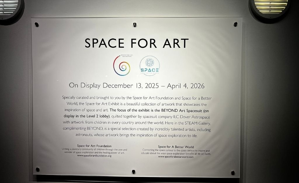 Wall sign for Space for Art exhibition at Orlando Science Center, showing display dates from December 13, 2025 to April 4, 2026, presented by the Space for Art Foundation.