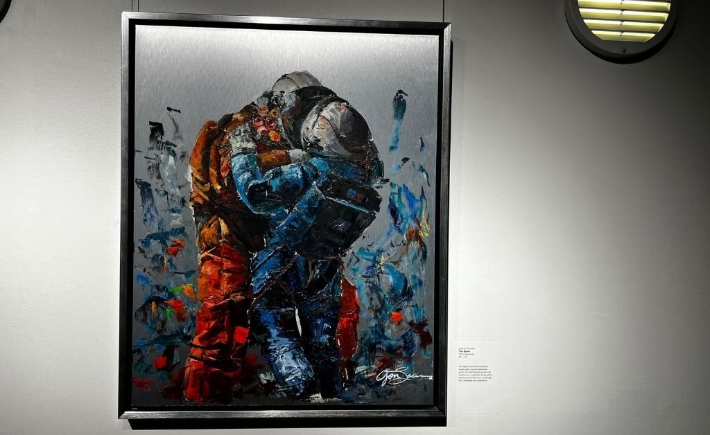 Oil painting of two astronauts embracing, titled The Spark by Jonlouis Gonzalez, displayed at the Space for Art exhibit.