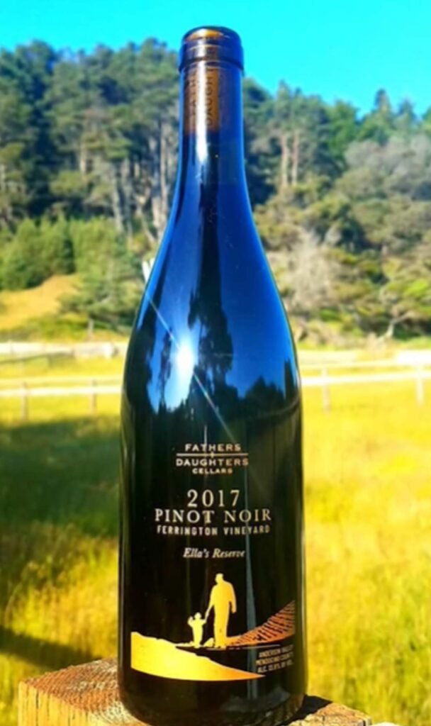 Bottle of Fathers + Daughters Cellars 2017 Pinot Noir Ella’s Reserve displayed outdoors at Ferrington Vineyard.