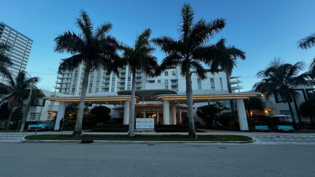 Front entrance and curved illuminated portico of Kimpton Shorebreak Fort Lauderdale at dusk