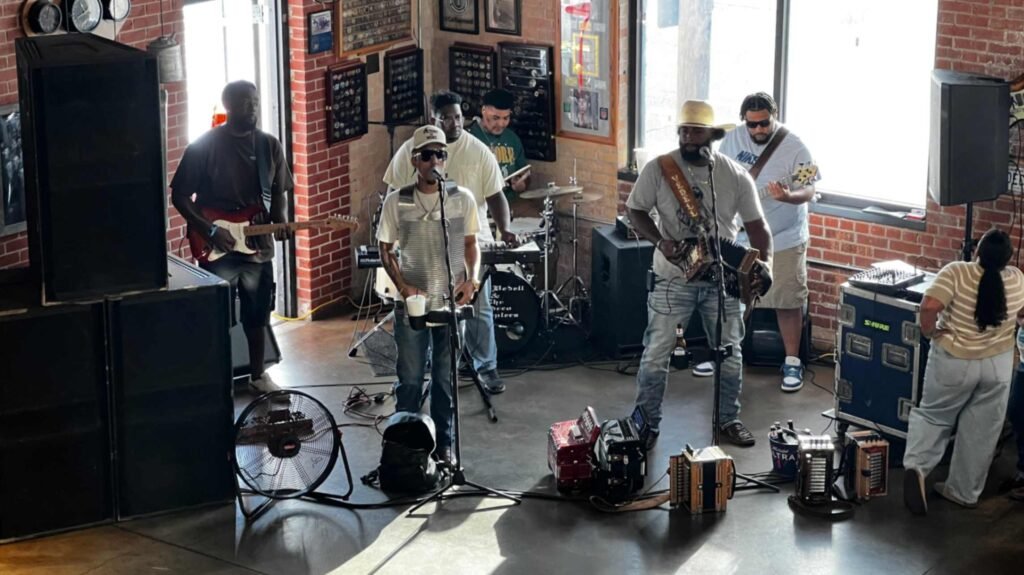 A live Zydeco band, including an accordion player, rubboard performer, and guitarists, performs on stage during the Zydeco Breakfast at Buck & Johnny's.